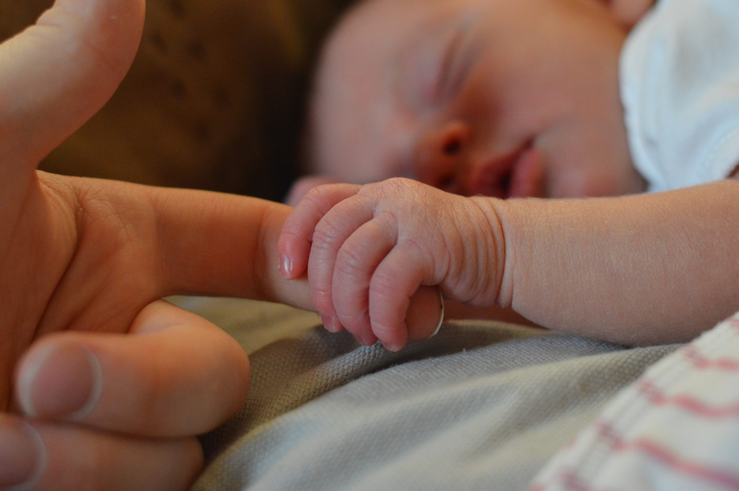 Holding sleeping baby's hand