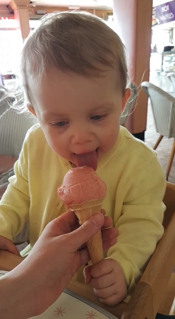 Toddler eating ice cream at Morelli's ice cream parlour in Broadstairs, Kent