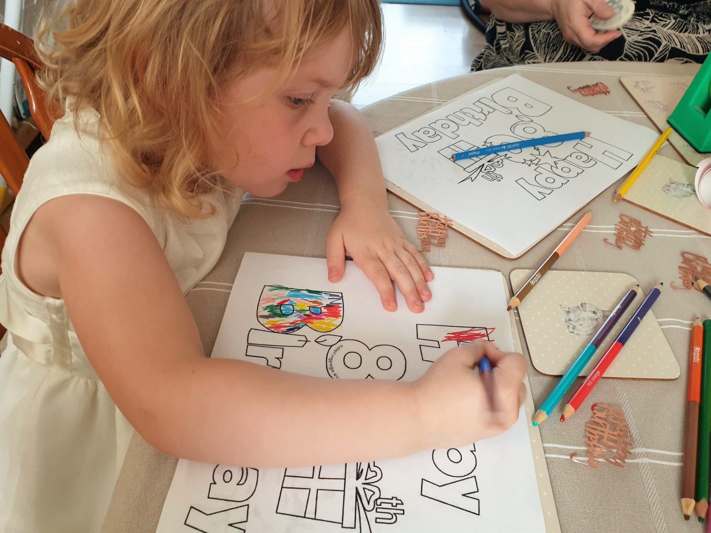 Child colouring in birthday banner